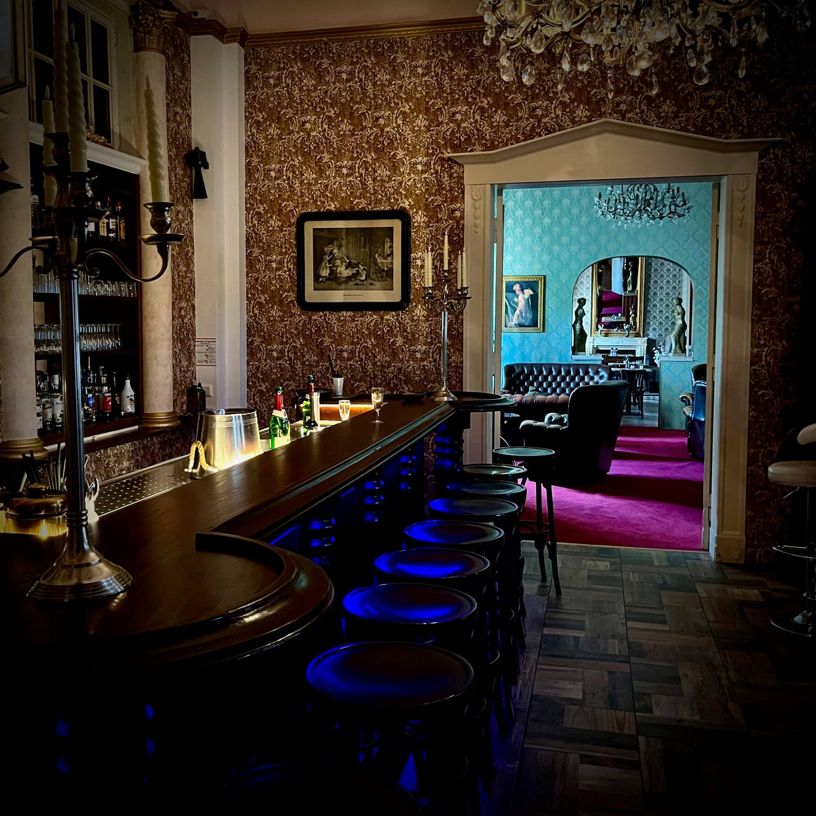 Die beleuchtete Bar mit Blick in den eleganten Salon von Schloss Trebbichau