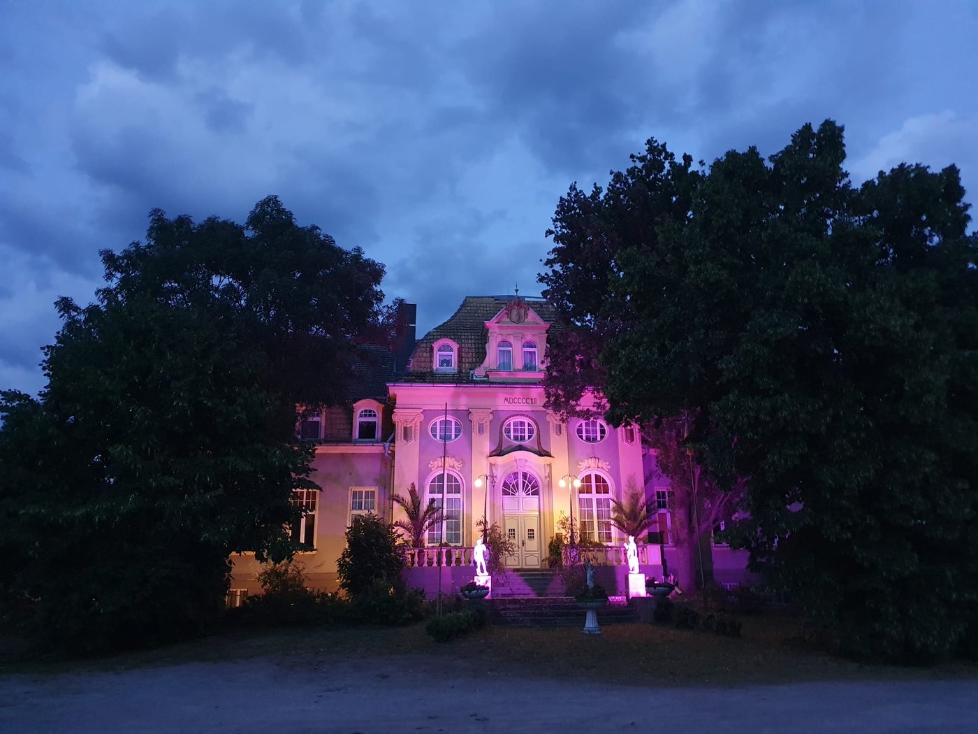 Schloss Trebbichau am Abend, festlich in Violett beleuchtet